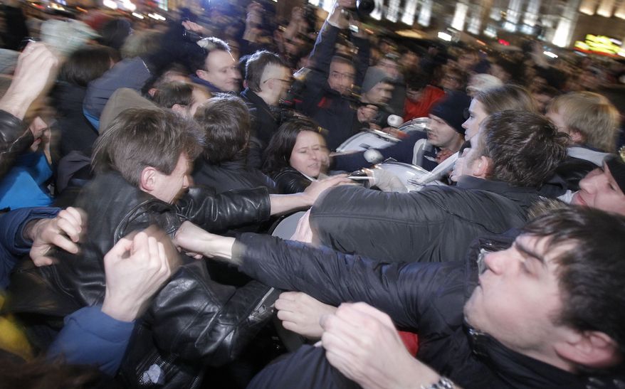 Opposition activists (left) and members of pro-Kremlin youth movements scuffle during demonstrations in Triumphal Square in Moscow on Tuesday, Dec. 6, 2011. (AP Photo/Ivan Sekretarev)