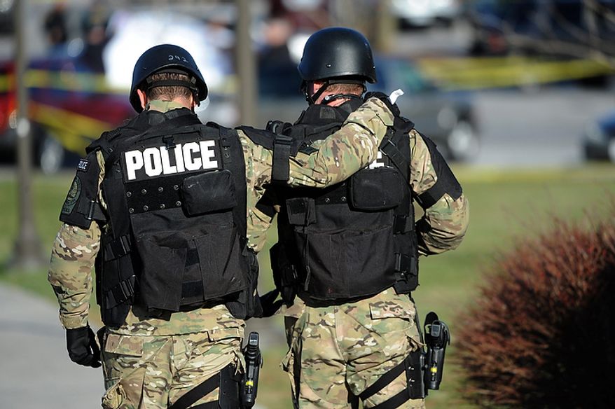 Virginia Tech police officers console one another as they move toward the scene where a fellow police officer was killed in a parking lot on the campus of Virginia Tech, Thursday December 8, 2011, in Blacksburg, Va. A man killed a police officer and another person after a traffic stop Thursday at Virginia Tech, sending a shudder through campus as students and faculty were told to stay inside and police searched for the gunman, school officials said. (AP Photo/Don Petersen)