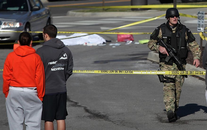 A police officer secures the scene where a gunman killed a police officer and another person after a traffic stop Thursday, Dec. 8, 2011 on the campus of Virginia Tech, in Blacksburg, Va. The school said a police officer pulled someone over for a traffic stop and was shot and killed. The shooter ran toward a nearby parking lot, where a second person was found dead. (AP Photo/The Roanoke Times, Matt Gentry)