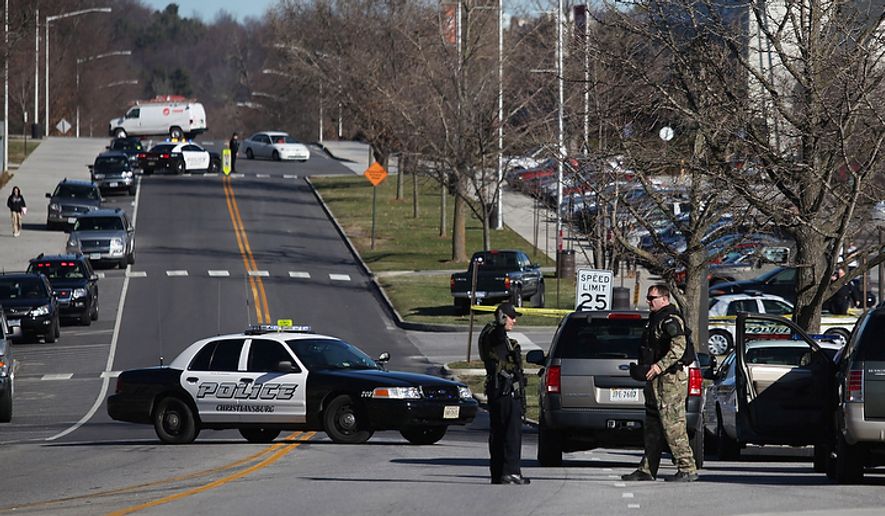 In this file photo, police officers block a road on the Virginia Tech campus in Blacksburg, Va., after a gunman killed a police officer and another person Thursday, Dec. 8, 2011. The school said a police officer pulled someone over for a traffic stop and was shot and killed. The shooter ran toward a nearby parking lot, where a second person was found dead. (AP Photo/The Roanoke Times, Matt Gentry) **FILE**