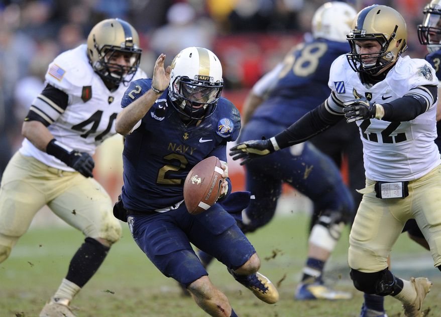 Navy quarterback Kriss Proctor rushes the ball as he is pressured by Army defenders Zach Watts and Nate Combs in the first half in Landover, Md., Saturday, Dec. 10, 2011. (AP Photo/Nick Wass)