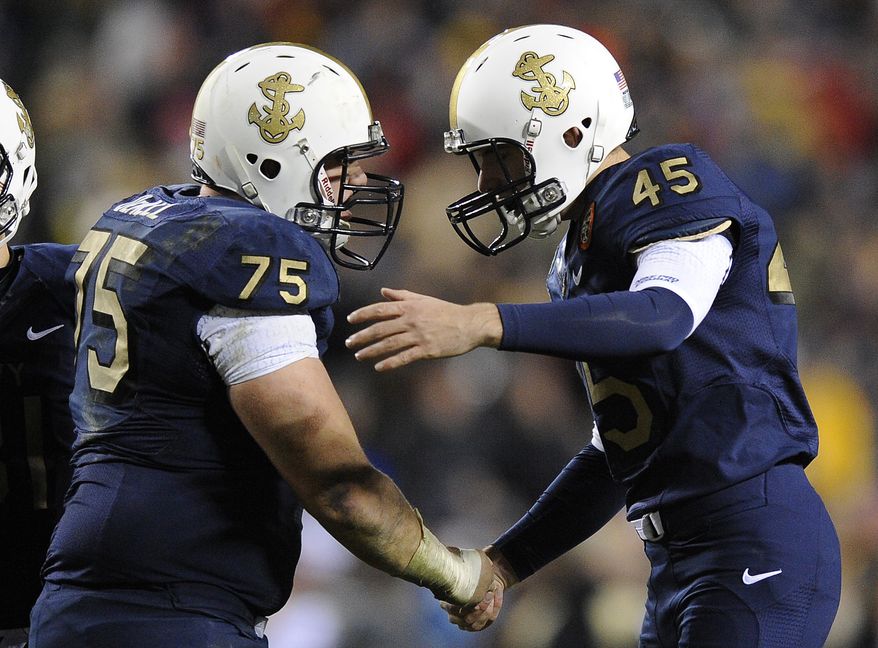 Navy center Brady DeMell shakes hands with kicker Jon Teague after Teague successfully kicked a field goal in the second half in Landover, Md., Saturday, Dec. 10, 2011. Navy won 27-21. (AP Photo/Nick Wass)