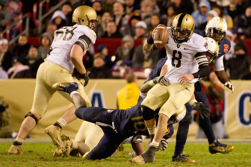 Navy linebackers Jarred Shannon (10) and Matt Warrick (obscured) sack Army quarterback Trent Steelman late in the fourth quarter during the annual matchup of the service academies. (Andrew Harnik/The Washington Times)