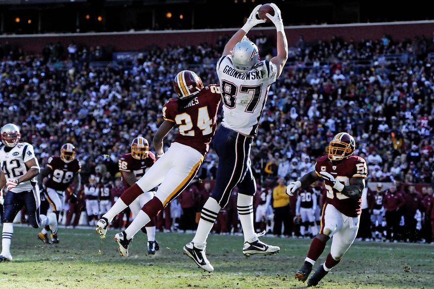 Patriots tight end Rob Gronkowski hauls in a first-quarter touchdown pass, his first of two scores, as the Redskins' DeJon Gomes defends. Gronkowski had six catches for 160 yards. (Preston Keres/Special to The Washington Times)