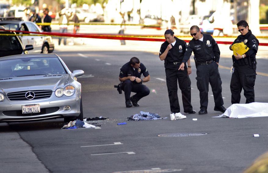 Investigators inspect the scene of a fatal shooting on Friday, Dec. 9, 2011, in the Hollywood area of Los Angeles after a gunman who fired at cars and shouted, "Kill me" and "I'm gonna die!" was shot to death by police. (AP Photo/Josh Edelson)