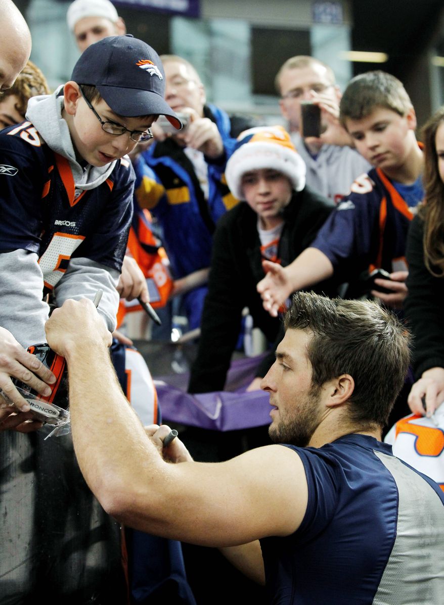 Denver Broncos quarterback Tim Tebow signs some autographs before a game Dec. 4 in Minneapolis. Mr. Tebow's exploits, including an overtime win Sunday, have made him "the talk of the NFL." (Associated Press)