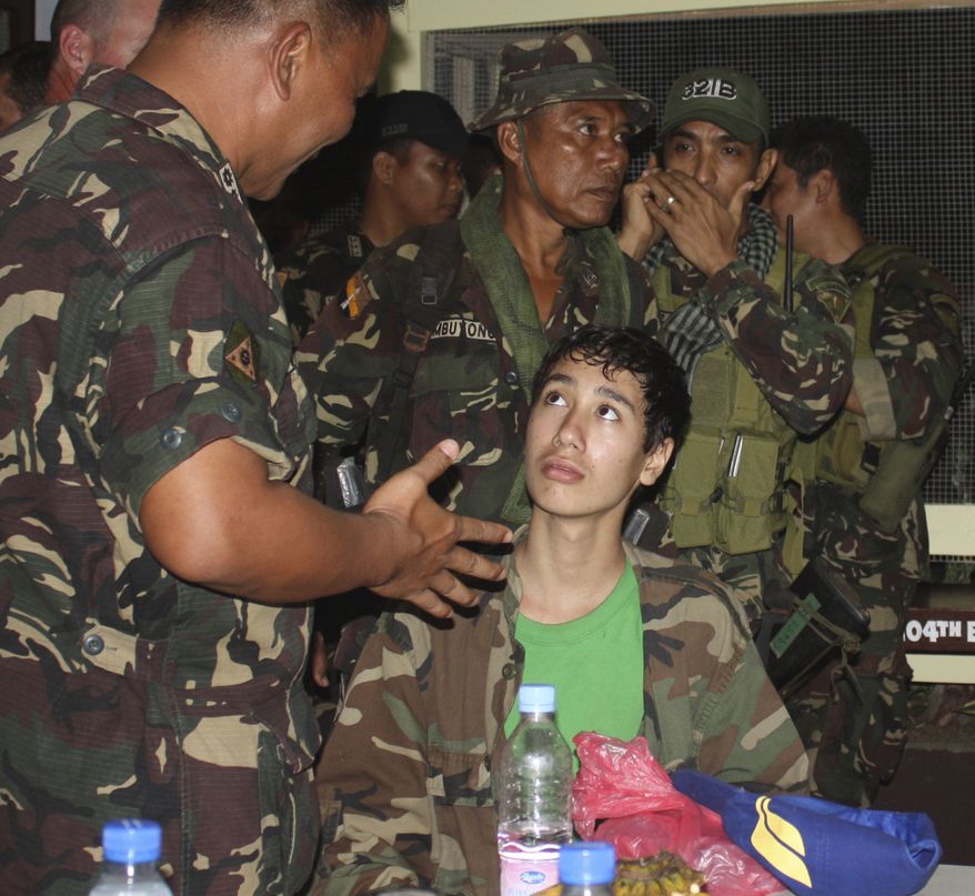 Kevin Lunsman, a kidnapped American teenage boy, talks Dec. 10, 2011, to Filipino soldiers inside the Philippine military compound in Zamboanga City, Philippines, following his escape from suspected al Qaeda-linked militants. (Associated Press)