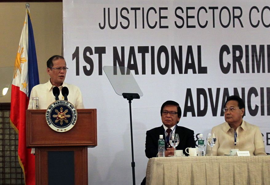 Philippine President Benigno Aquino III (left) addresses the National Criminal Justice Summit in Manila on Monday, Dec. 5, 2011, as Supreme Court Chief Justice Renato Corona (right) and Anti-Graft Court Presiding Justice Francisco Villaluz Jr. listen. (AP Photo/Malacanang Palace Photo Bureau, Gil Nartea)