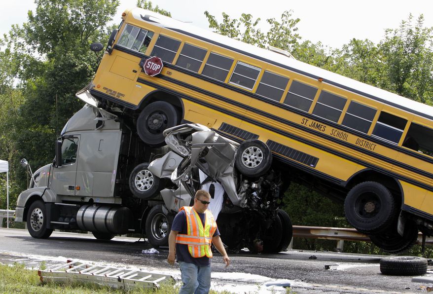 A rescue worker is seen Aug. 5, 2010, at the scene of an accident involving two school buses, a tractor-trailer and another passenger vehicle near Gray Summit, Mo. Federal safety investigators say a 19-year-old driver was texting at the time his pickup truck, two school buses and other vehicles collided in a deadly pileup on an interstate highway in Missouri. (Associated Press)