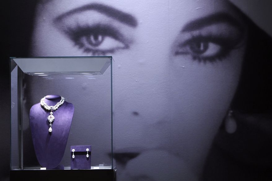 "La Peregrina" (left), a natural pearl, diamond and ruby necklace by Cartier, and a pair of natural pearl and diamond ear pendants by Bulgari are on display during a preview of Elizabeth Taylor's jewelry collection at Christie's in New York on Thursday, Dec. 1, 2011. (AP Photo/Mary Altaffer)
