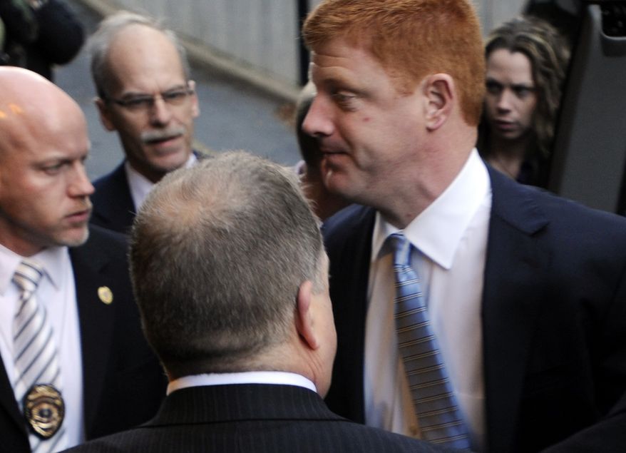Penn State assistant football coach Mike McQueary (right) arrives Dec 16, 2011, for a preliminary hearing related to the Jerry Sandusky child sex abuse case at Dauphin County Court in Harrisburg, Pa., surrounded by heavy security. (Associated Press)