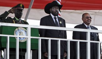 **FILE** South Sudan&#39;s President Salva Kiirr (center) and Sudan&#39;s President Omar al-Bashir (right) stand July 9, 2011, on the podium at the start of independence celebrations in Juba, South Sudan. South Sudan raised the flag of its new nation for the first time, as thousands of South Sudanese citizens swarmed the capital of Juba to celebrate the country&#39;s birth. (Associated Press)