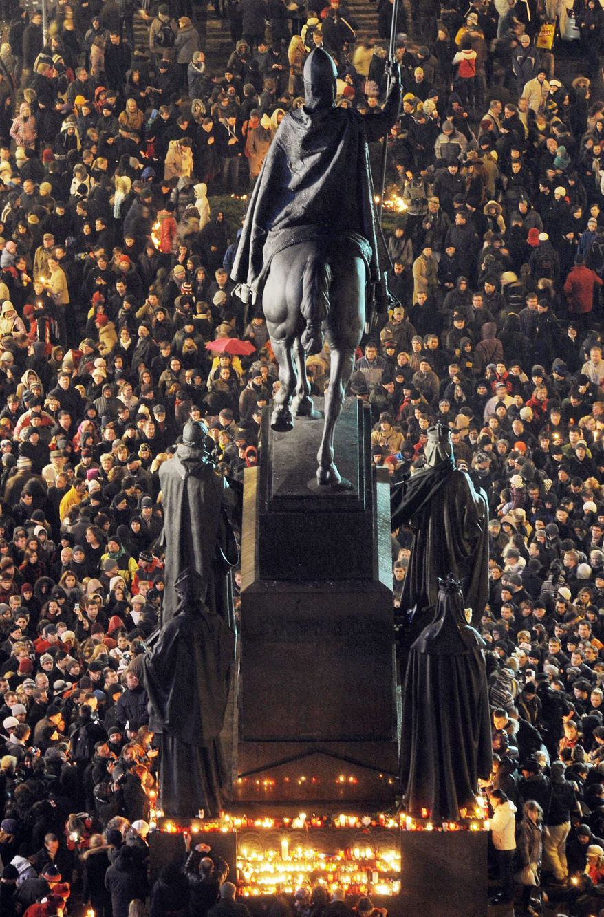 People surround St. Wenceslas statue at Wenceslas Square in Prague on Sunday to pay tribute to Vaclav Havel. The former Czech president died early Sunday morning at his country home in Hradecek, northeast of Prague. He was 75. (Associated Press)