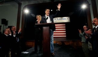 Republican presidential candidate Mitt Romney waves as he wife, Ann, applauds after a campaign speech in Bedford, N.H., on Tuesday. Mr. Romney indicated that he favors campaigns themselves being able to accept and spend donations of any size. (Associated Press)