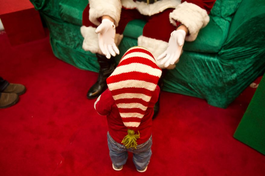 Michael Graham, who plays Santa at Tyson's Corner Center tries to coerce 14 month year old Brody Spaulding of Falls Church, VA into coming to sit on his lap, Tyson's Corner, VA, Wednesday, December 14, 2011. (Andrew Harnik / The Washington Times)
