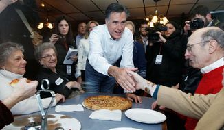 PIZZA PARLOR POLITICIAN: Former Massachusetts Gov. Mitt Romney, a Republican presidential contender, shakes hands with patrons while campaigning at Village Pizza in Newport, N.H. (Associated Press)
