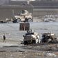 A Polish military armored vehicle (right) was destroyed by a roadside bomb in Ghazni, Afghanistan, southwest of Kabul, on Wednesday, Dec. 21, 2011. Five Polish soldiers were killed in the blast. (AP Photo/Rahmatullah Nikzad)