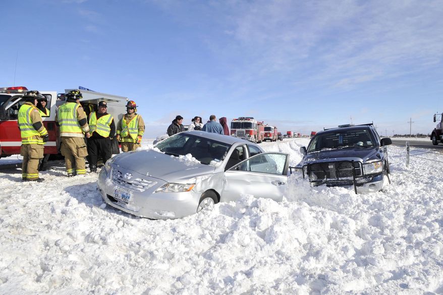 Emergency responders assists victims of a multiple-vehicle accident on westbound Interstate 40 about 15 miles west of Amarillo, Texas, on Tuesday, Dec. 20, 2011. (AP Photo/The Amarillo Globe News, Michael Schumacher)