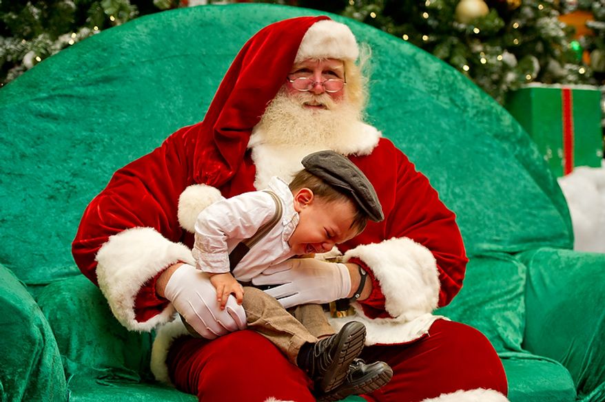 Michael Graham, who plays Santa Claus at Tysons Corner Center in Tysons Corner, tries to calm a very upset 18-month-old Thiago Heath of Falls Church on the child's first visit with Santa on Wednesday, Dec. 14, 2011. This is Mr. Graham's 22nd year as Santa at the shopping center, where, from Thanksgiving to Christmas Eve, he can be seen greeting children and some young adults. (Andrew Harnik/The Washington Times)