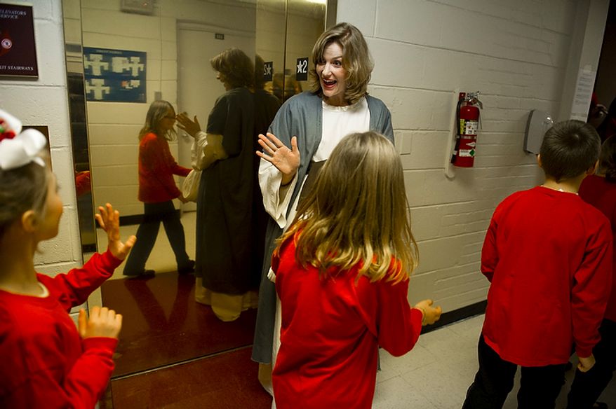 Mary, played by Sara Butler, waves to children en route to the stage for the performance of the 2011 Living Christmas Tree program "Christmas Is Relative" at the First Baptist Church of Alexandria on Wednesday, Dec. 7, 2011. Mrs. Butler's husband, David, plays Joseph. The production features traditional and contemporary holiday music and a 25-foot Christmas tree filled with 100 singers and more than 50,000 synchronized lights. (Rod Lamkey Jr./The Washington Times)