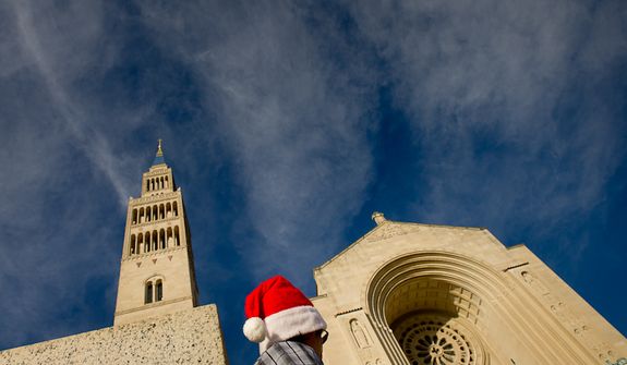 Diego A. of Germantown, Md., wears a santa hat before heading into Mass at the Basilica of the National Shrine of the Immaculate Conception on Christmas Day, Washington, D.C., Sunday, Dec. 25, 2011. The Archbishop of Washington Cardinal Donald Wuerl held Christmas Mass at noon. (Andrew Harnik/The Washington Times)