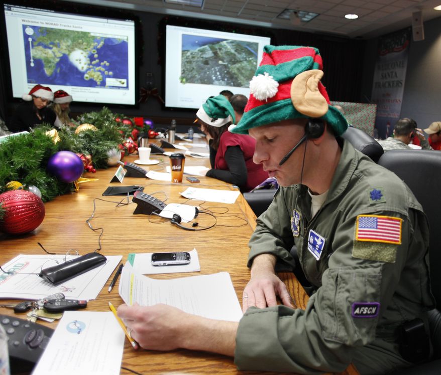 ** FILE ** Air Force Lt. Col. David Hanson of Chicago takes a phone call from a child in Florida at the Santa Tracking Operations Center at Peterson Air Force Base near Colorado Springs, Colo., on Dec. 24, 2010. (AP Photo/Ed Andrieski)