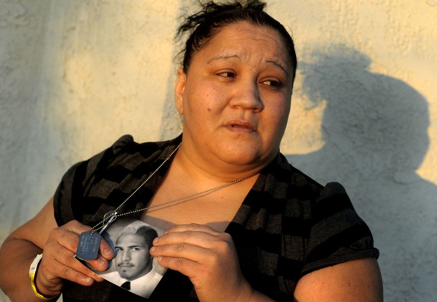 Suzanne Sullivan holds a photo of her son, Army Spec. Christopher Sullivan, outside her home in San Bernardino, Calif., on Saturday, Dec. 24, 2011. (AP Photo/The San Bernardino Sun, Gabriel Luis Acosta)