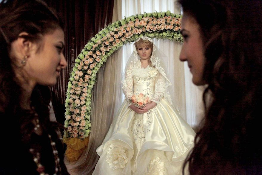 Elina Mutsaev, 17, wears a silk gown embroidered with gold thread and seed pearls, plus diamond ornaments in her hair, for her wedding. An average wedding in Chechnya costs $3,000 to $20,000 as sudden prosperity encourages conspicuous luxury. (Diana Markosian/Special to The Washington Times)