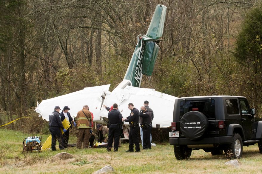 Authorities inspect a private plane that crashed into a field in South Knoxville, Tenn., on Dec. 26, 2011. (Associated Press/The Knoxville News Sentinel)