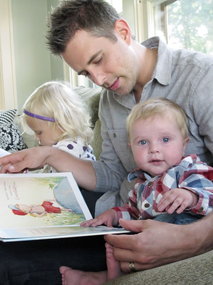 Matt Hammitt, lead singer for the Christian rock band Sanctus Real, reads a book to his 1-year-old son, Bowen, at their home. (Associated Press)