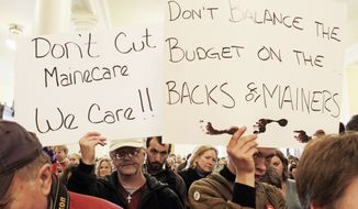 **FILE** Dozens voice their concerns about proposed budget cuts in the Medicaid system during a rally at the State House in Augusta, Maine, on Dec. 14, 2011. (Associated Press)
