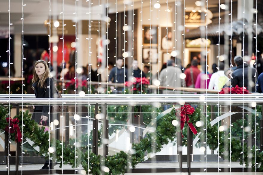 Caitlin Schultz, 18, of Waldorf, Md., at left, crosses bridge near decorations of hanging lights as shoppers crowd the Tysons Corner Center mall in McLean, Va., for returns and after-Christmas sales on Dec. 26, 2011. (T.J. Kirkpatrick/ The Washington Times)