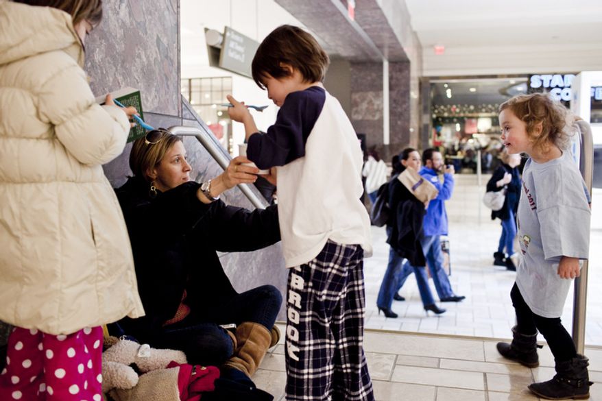Meredith Wade, second from left, of Bethesda, Md., shares ice cream with her children, Olivia, 7, form left, Caleb, 5, and Juliet, 3, after seeing a movie at the Tysons Corner Center mall in McLean, Va. on Dec. 26, 2011. "Before I had kids, I would brave any crowd for a sale," said Meredith, "but now I won't go in to a store." (T.J. Kirkpatrick/ The Washington Times)