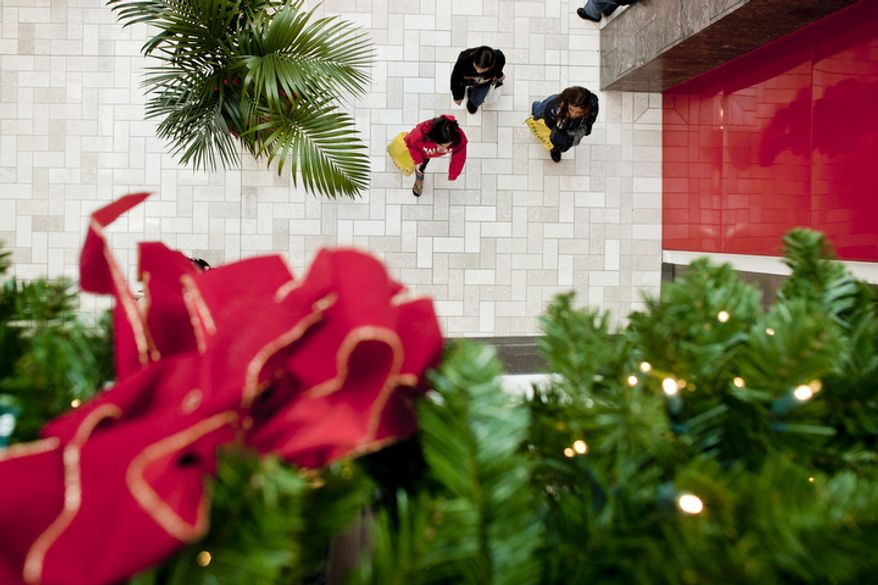 Shoppers walk among Christmas decorations in the Tysons Corner Center mall in McLean, Va., for returns and after-Christmas sales. Tysons Corner Center reports a 10 percent jump in foot traffic compared to last year's holiday season.
(T.J. Kirkpatrick/ The Washington Times)