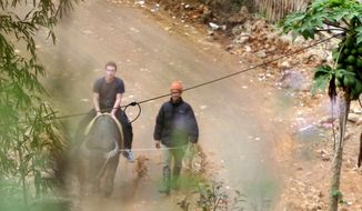 In this Dec. 26, 2011, photo, Facebook website founder Mark Zuckerberg rides a water buffalo in northern resort town of Sapa in Lao Cai province, Vietnam. (AP Photo/VnExpress, Le Thanh Hieu) 