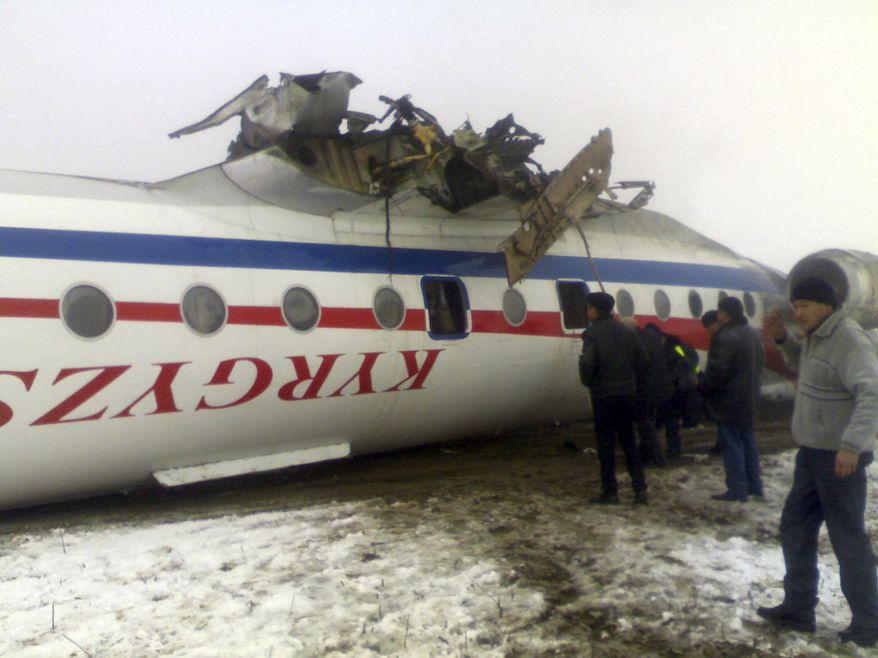 Emergency rescue personnel inspect an overturned Soviet-built Tupolev Tu-134 passenger jet after it crash-landed in dense fog in Osh, Kyrgyzstan, on Wednesday, Dec. 28, 2011. Authorities said 31 people were injured. (AP Photo/AKI Press, Pool)