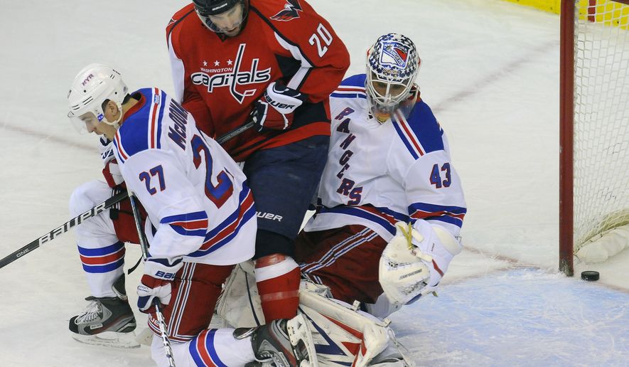 New York Rangers&#x27; goalie Martin Biron has his vision blocked by teammate Ryan McDonagh (27) as Washington Capitals&#x27; Troy Brouwer (20) slips the puck slip past him during second period of their NHL game, Wednesday, Dec. 28, 2011, in Washington. (AP Photo/Richard Lipski)