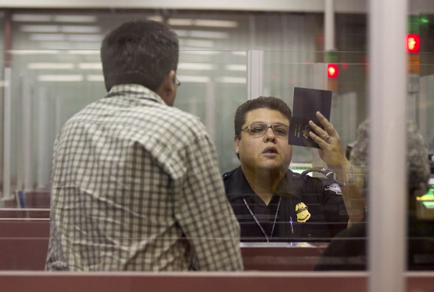 A U.S. Customs and Border Protection officer checks the passport of a foreign visitor at McCarran International Airport in Las Vegas on Tuesday, Dec. 13, 2011. (AP Photo/Julie Jacobson)