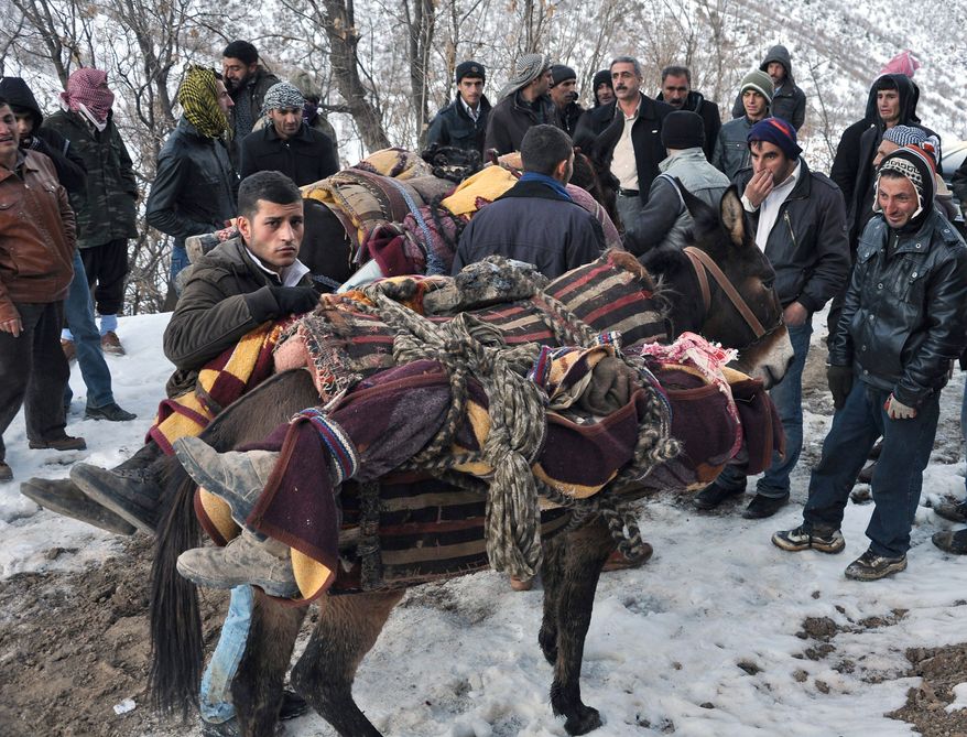 People mount bodies onto mules after Turkey's air force attacked suspected Kurdish rebels on Wednesday night, killing 35, many of them believed to be smugglers mistaken for guerrillas. It was one of the largest one-day civilian death tolls incurred during Turkey's 27-year drive against militant Kurds seeking autonomy. (Associated Press)