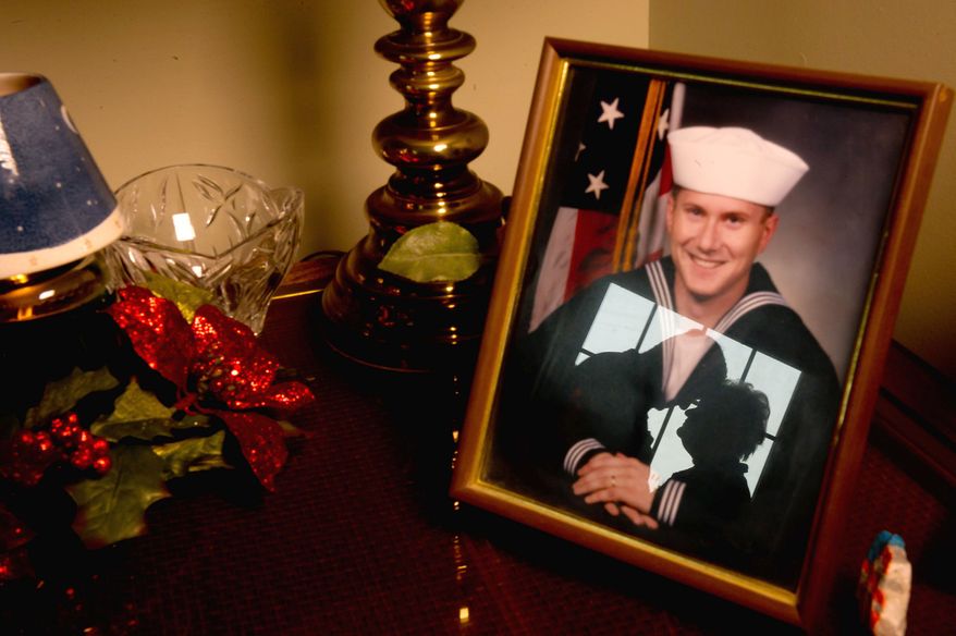 'CONNECTION': Bob and Carol Roddy are reflected in a portrait of son David, who died in Iraq in 2006. The Roddys have volunteered at BWI's USO lounge since 2008 as a way to ease the pain and stay busy. (Andrew Harnik/The Washington Times)
