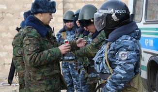 **FILE** A Kazakh riot police officer (left) instructs others Dec. 17, 2011, before their patrol in center of Zhanaozen, Kazakhstan. (Associated Press)