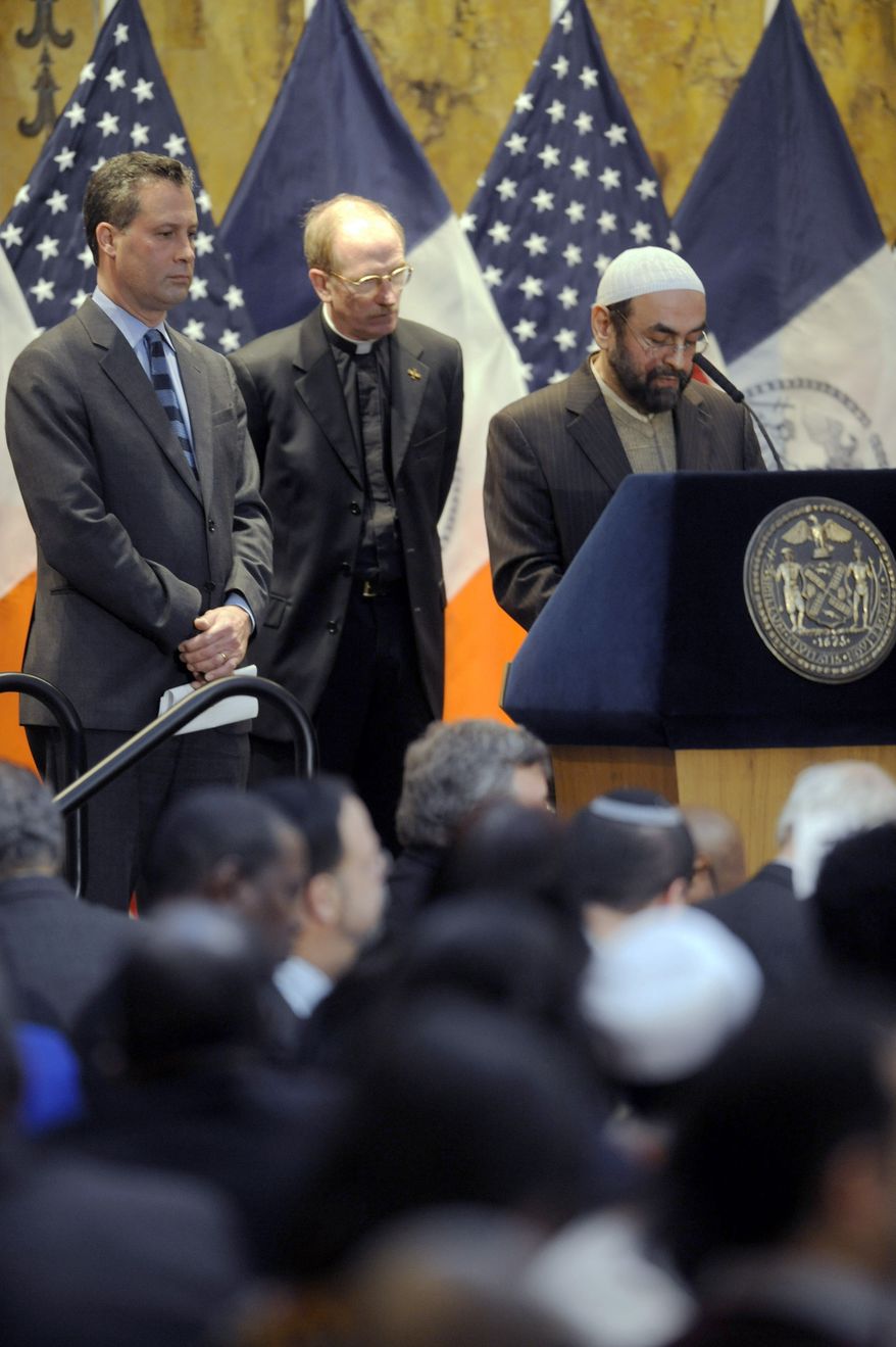 Imam Mohammed Sherzad (right) gives an invocation while Dr. Anthony Marx (left), president and CEO of the New York Public Library, and Father Joseph McShane of Fordham University, listen Dec. 30, 2011, during the mayor's annual interfaith breakfast at the New York Public Library in New York. (Associated Press)