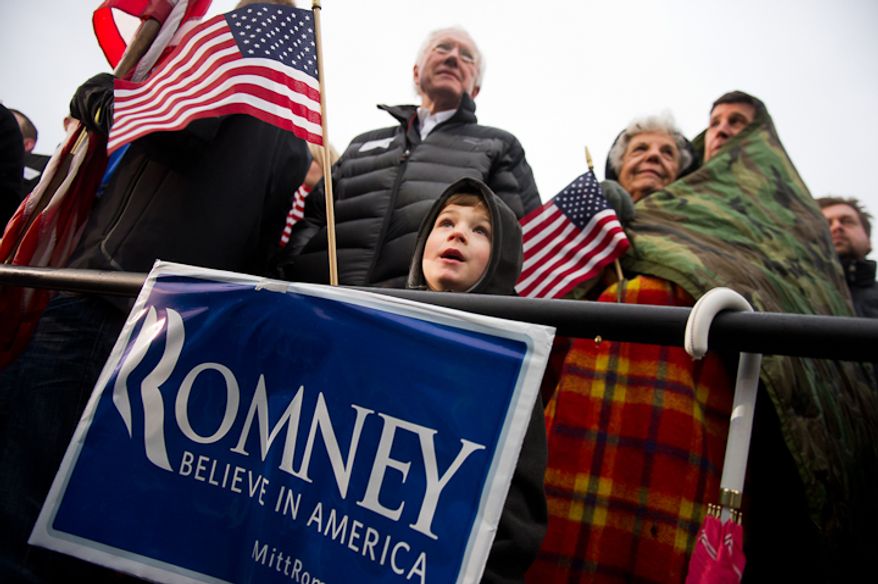 Left to right: Bill Koenig of West Des Moines with his 5 year old grandson Graham Kenworthy braves the cold and rain alongside Marcella Yochum and her son Scott Yochum to see Republican presidential candidate Mitt Romney speak at an early morning rally at a Hy-Vee grocery store, West Des Moines, IA, Friday, December 30, 2011. (Andrew Harnik / The Washington Times)