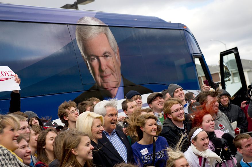 Juniors and seniors from Taylor High School in Cincinnati pose for a photo amid strong, cold winds with Republican presidential hopeful Newt Gingrich and wife Callista outside of the West Towne Pub in Ames, Iowa, where he was meeting Sunday with supporters. (Andrew Harnik/The Washington Times)