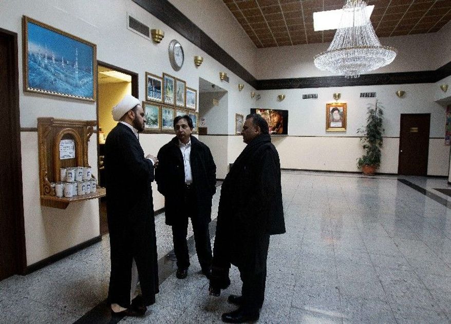 Imam Maan Al-Sahlani (left) speaks with Syed Raza and Javaid Hussain in the lobby of the Iman Al-Khoei Islamic Center in New York on Monday, a day after someone hurled a Molotov cocktail at the building's facade. Police are also investigating similar attacks on a nearby bodega and two houses as possible bias crimes. (Associated Press)