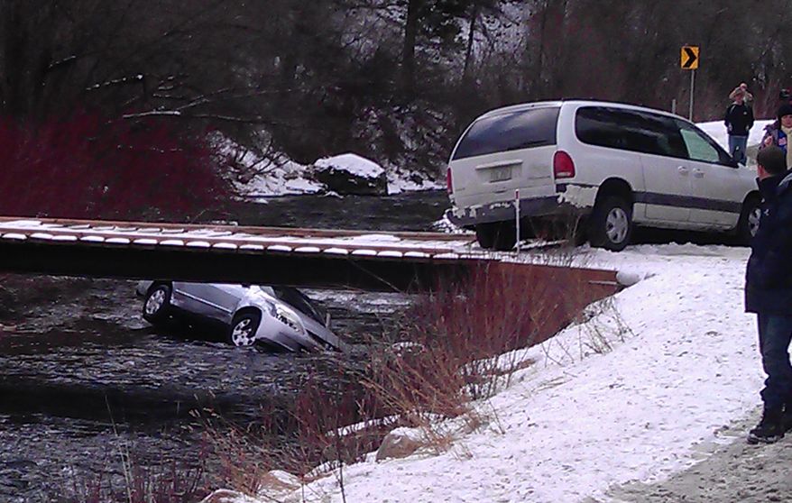 A photo provided by Chris Willden shows a car in the Logan River in Utah on Dec. 31, 2011, after the car was flipped upright by rescuers who saved three children trapped inside. After the car plunged off an embankment into the river, Willden shot out the car's window with a handgun and cut a seat belt to help free the children. (Associated Press)