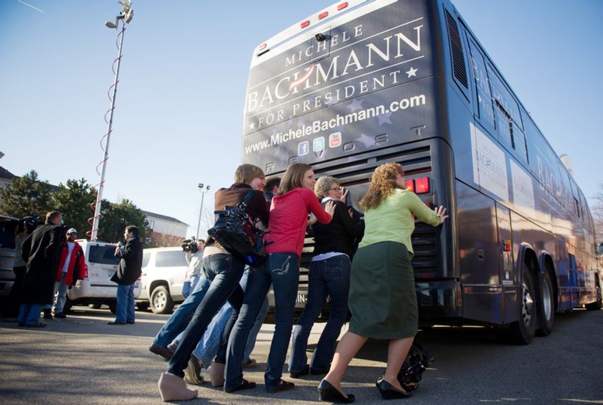 Rep. Michele Bachmann's campaign staff poses for a photo behind her bus on Wednesday, Jan. 4, 2012, in West Des Moines, Iowa, after Mrs. Bachmann announced the end of her Republican presidential campaign following a sixth-place finish in Tuesday's Iowa Republican caucuses. (Andrew Harnik/The Washington Times)