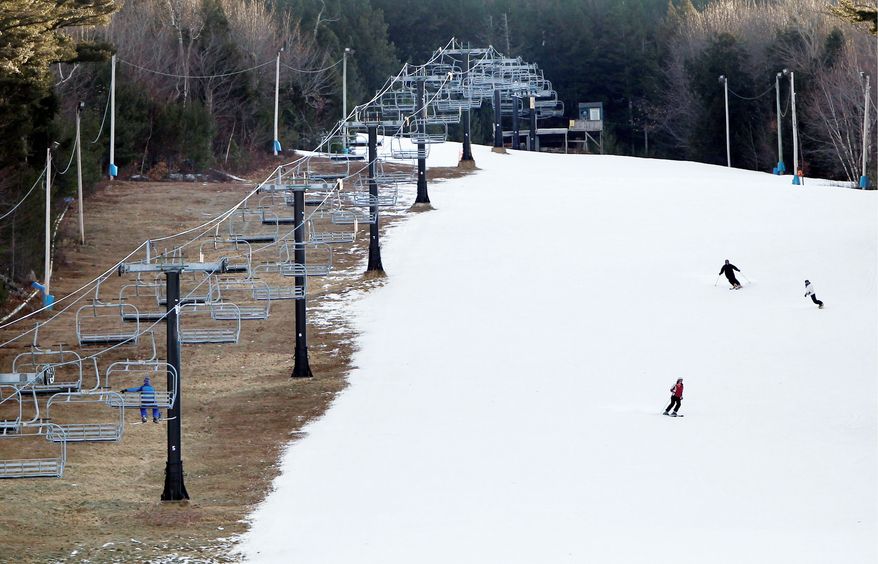 Man-made snow coats a ski slope, but barren ground remains Thursday under a chairlift at Shawnee Peak ski resort in Bridgton, Maine. A dearth of snow in many regions nationwide is costing various businesses millions of dollars. (Associated Press)