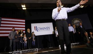 With his family behind him, former Massachusetts Gov. Mitt Romney campaigns for the Republican presidential nomination at McKelvie Intermediate School in Bedford, N.H., on Monday, Jan. 9, 2012. (AP Photo/Charles Dharapak)