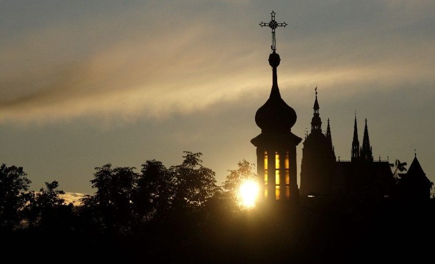 The sun sets behind St. Vitus Cathedral in Prague in 2009. The Czech Republic's coalition government has OK'd a plan to compensate religious organizations for property seized by the former Czechoslovakia's communist regime. (Associated Press)